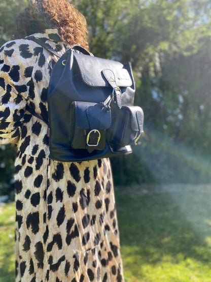 Mochila de cuero negro artesanal Rufah en uso, llevada en la espalda, mostrando su tamaño y diseño con bolsillos frontales.